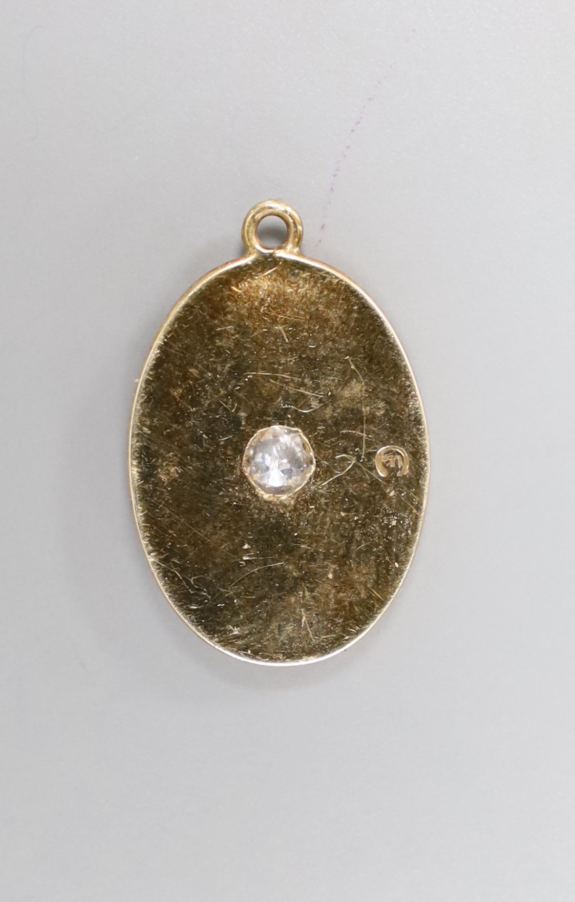 A yellow metal and single stone diamond set oval pendant, 19mm, gross 3 grams.